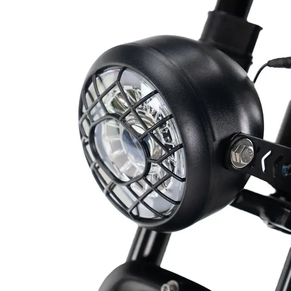 Fatbike Ouxi V8 2025 en noir, détail du phare LED rond avec grille de protection noire