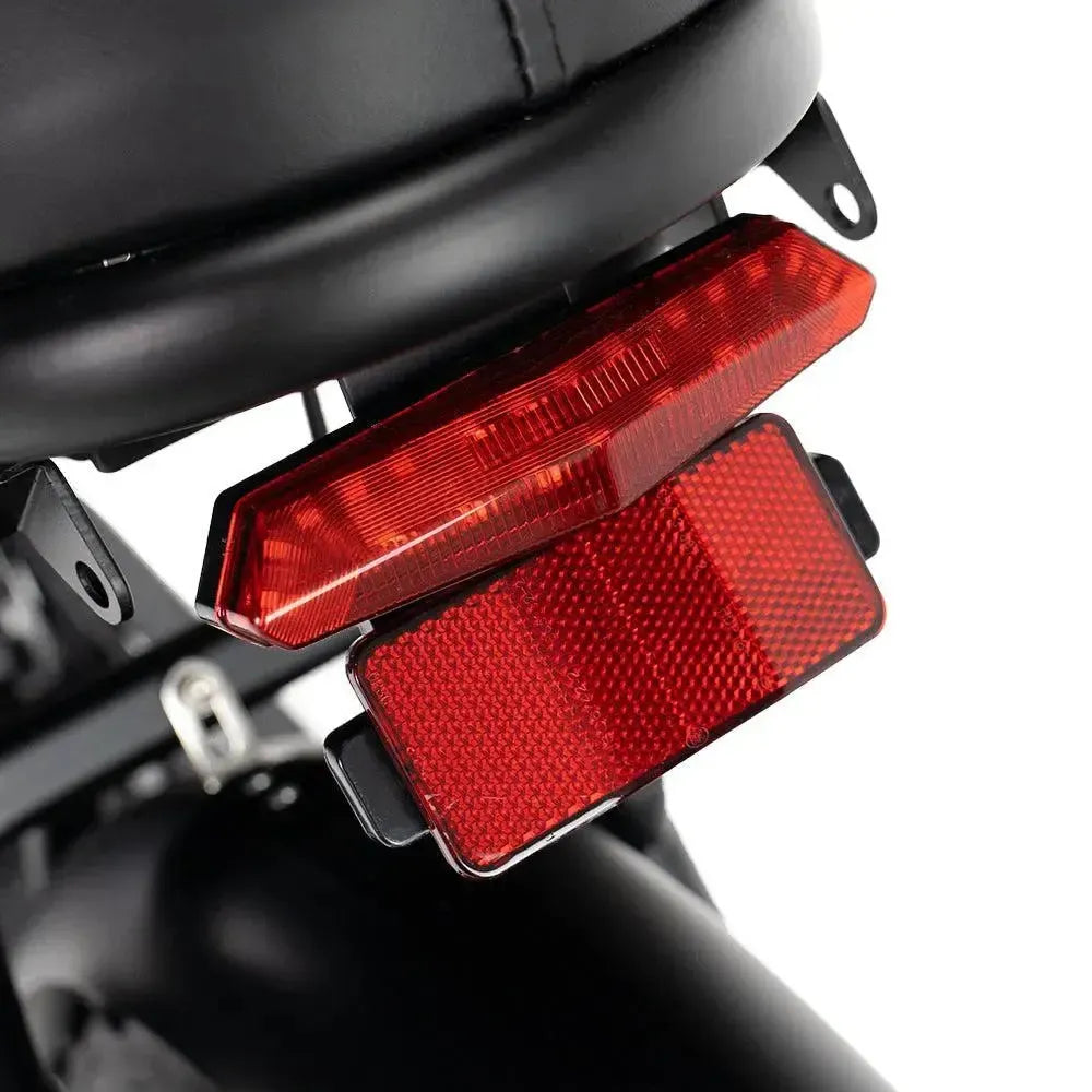 Fatbike Ouxi V8 2025 en noir, détail du feu arrière rouge avec réflecteur sous la selle